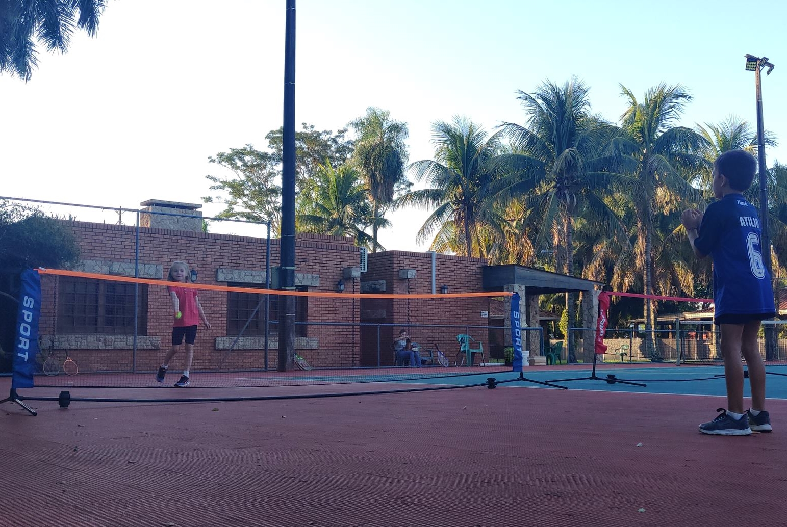 Young girl serving tennis ball